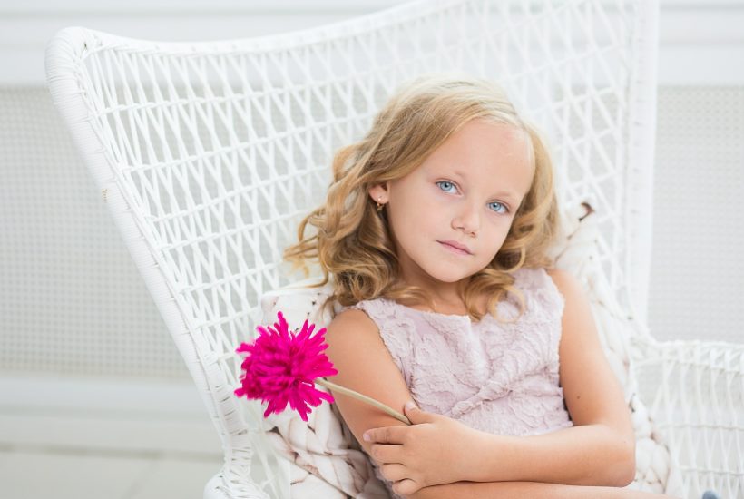 A cute girl with pink flower on her hand